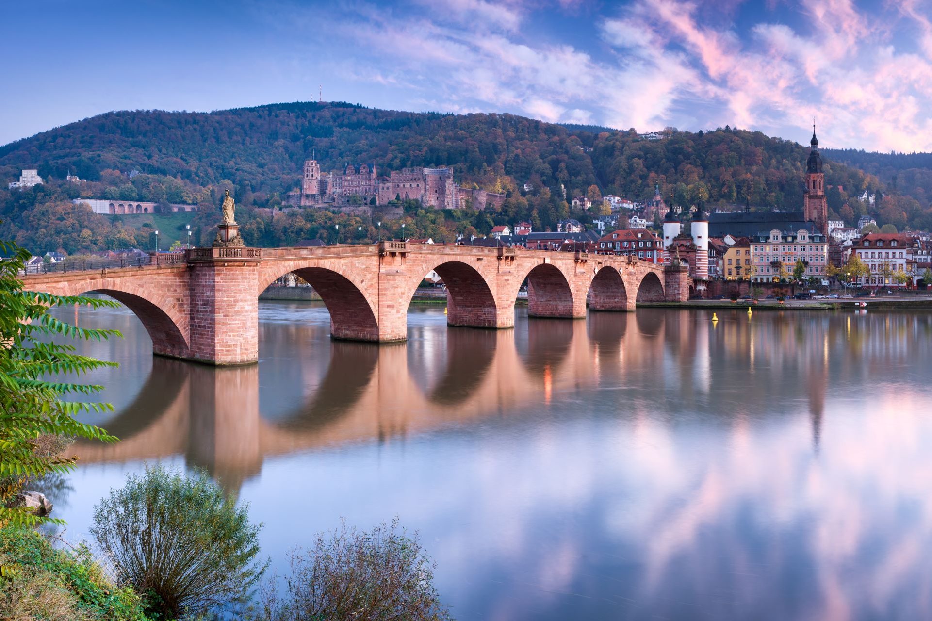 Eine alte BrÃ¼cke in Heidelberg, die Ã¼ber dem Neckar verlÃ¤uft.
